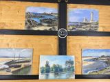 quatre tableaux accrochés au mur d'une pièce où se trouve une horloge
