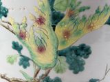 a vase with a bird painted on it sitting on a table