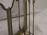 a brass fire place with a broom and a mirror