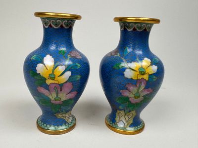 une paire de vases bleus ornés de fleurs jaunes sur un fond blanc