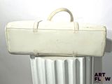 a white suitcase sitting on top of a radiator