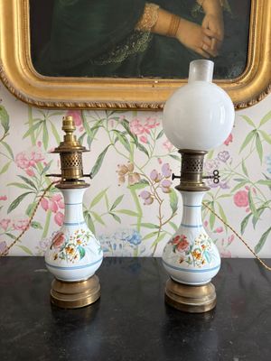 deux lampes posées sur une table devant un tableau