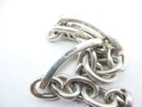 a close up of a silver chain on a white surface