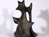 une sculpture en bronze représentant un chat assis sur une table