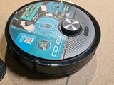 a robot that is sitting on the floor next to a remote