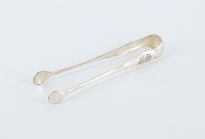 a pair of silver spoons sitting on top of a white surface