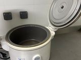 a white crock pot sitting on the floor next to a wall