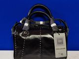 a black purse with a tag on it on a table