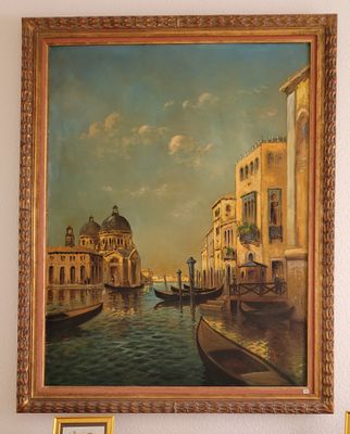 un tableau représentant une gondole accroché au mur, à côté d'un tableau représentant un canal