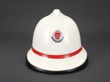 a close up of a white fireman ' s hat with a red band