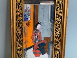 une vieille photo d'une femme en robe rouge assise devant un miroir