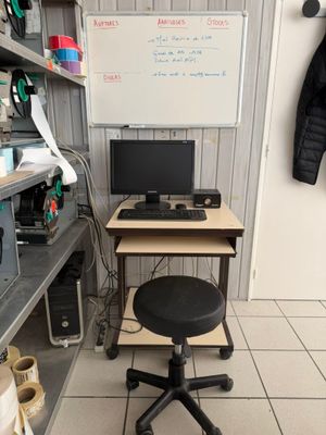 a desk with a computer and a chair in a room