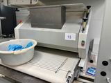 une machine équipée d'un bac placé sur un tapis roulant