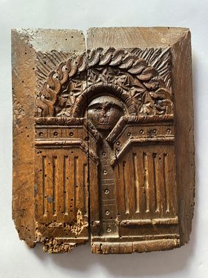 une photo d'une plaque en bois sur laquelle figure l'image d'un homme dans une entrée
