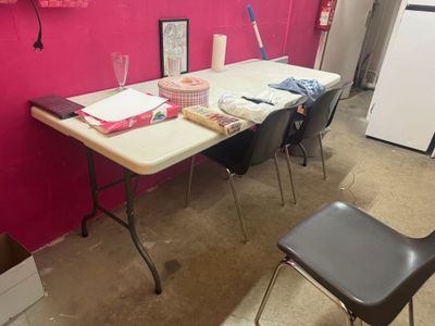 une table et une chaise dans une pièce aux murs roses