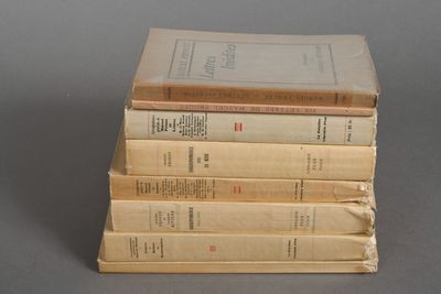 several old books stacked on top of each other on a table
