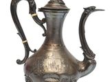 an old silver tea pot with a bird on top of it