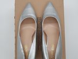 the silver shoes are sitting on top of a cardboard box