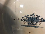 a blue and white plate with a flower design on it