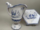 a blue and white pitcher and a plate on a table