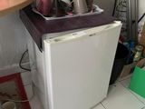 un petit réfrigérateur blanc dans le coin d'une cuisine