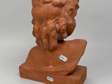an image of a clay sculpture of a man ' s head on a wooden base