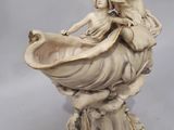 an antique ivory figurine of a woman holding a bowl