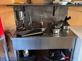 une petite cuisine équipée d'une cuisinière, d'un évier et d'un réfrigérateur
