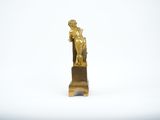 gold statue of a man holding a dog on a pedestal