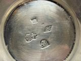 a silver plate with a cross on it on a table