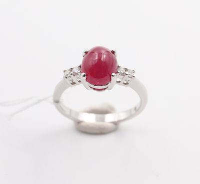 an oval ruby and diamond ring on a white background