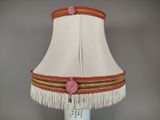 a lamp that has a white shade with a red flower on it
