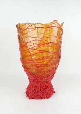 un vase en verre entouré d'une corde rouge