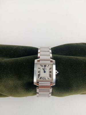 une photo d'une montre en argent posée sur une serviette verte