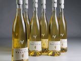 six bouteilles de vin blanc sont alignées