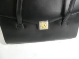 a close up of a black handbag with a gold buckle