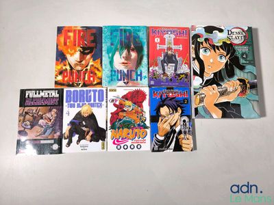 beaucoup de livres sur les anime qui sont posés sur la table