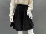 an image of a mannequin wearing a white blouse and black skirt