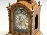une petite horloge en bois posée sur une table