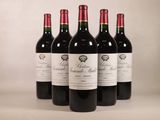 quatre bouteilles de vin rouge sont alignées sur une table