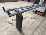 an image of a conveyor belt in a warehouse with a machine in the background