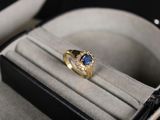 une bague en or sertie d'une pierre bleue, dans un écrin