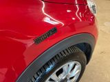 a close up of a red car with a sticker on it