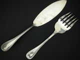 deux fourchettes et un couteau posés sur une table noire