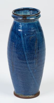 a blue vase that is sitting on a white surface