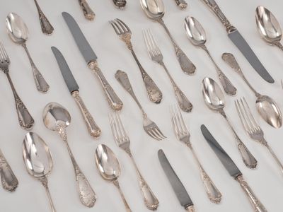 de nombreuses cuillères et fourchettes disposées sur la table