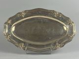 an antique silver plate with a decorative design on it