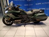 a picture of a green motorcycle parked in front of a blue wall