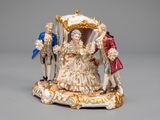 a figurine of a man and a woman in a carriage