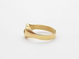 a close up of a gold ring on a white surface